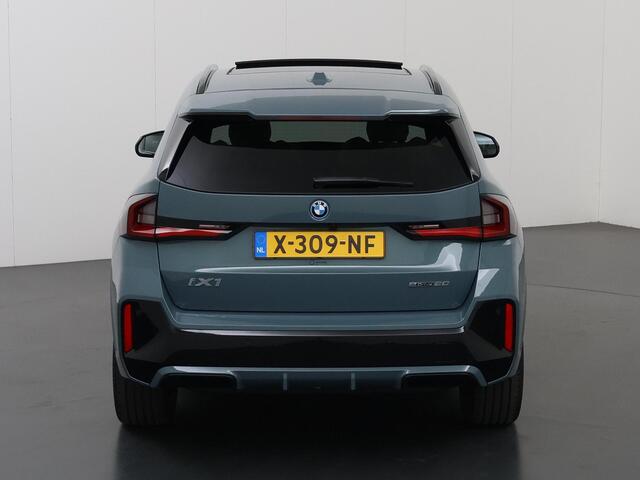 BMW iX1 eDrive20 67 kWh M-Pakket | SOH 98% | Panormadak | Sportstoelen | Curved Display | Harman/Kardon | Camera | Apple CarPlay/Android Auto | Ele.verstelbare stoelen + Geheugen | Ele. kofferdeksel |