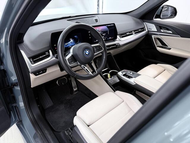 BMW iX1 eDrive20 67 kWh M-Pakket | SOH 98% | Panormadak | Sportstoelen | Curved Display | Harman/Kardon | Camera | Apple CarPlay/Android Auto | Ele.verstelbare stoelen + Geheugen | Ele. kofferdeksel |