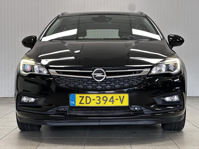 Opel ASTRA Sports Tourer 1.0 Business Executive/ Trekhaak/ 16'' LMV/ Keyless/ Apple + Android/ PDC V+A/ DAB+/ Navi/ Clima/ Cruise/ Elek. pakket/ Isofix/ Bluetooth/ Multi. LEDER. Stuur/ Mistl./ Chroom/ Dakrails.