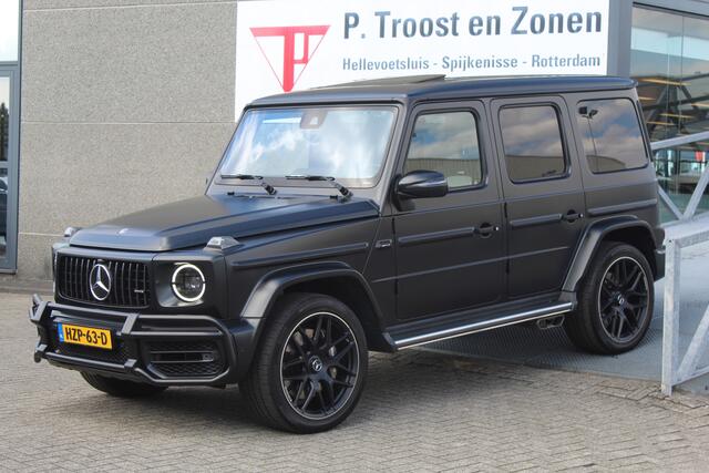 Mercedes-Benz G-KLASSE 63 AMG Night pakket/Magno matt/Panoramadak/Burmester audio/Sfeerverlichting/Entertainment schermen achter/Akrapovic/AMG active ride control/Elektrisch verstelbare stoelen met memory + massage/Stoel verwarming + koeling/360° camera/voorruitverwarming/IWC